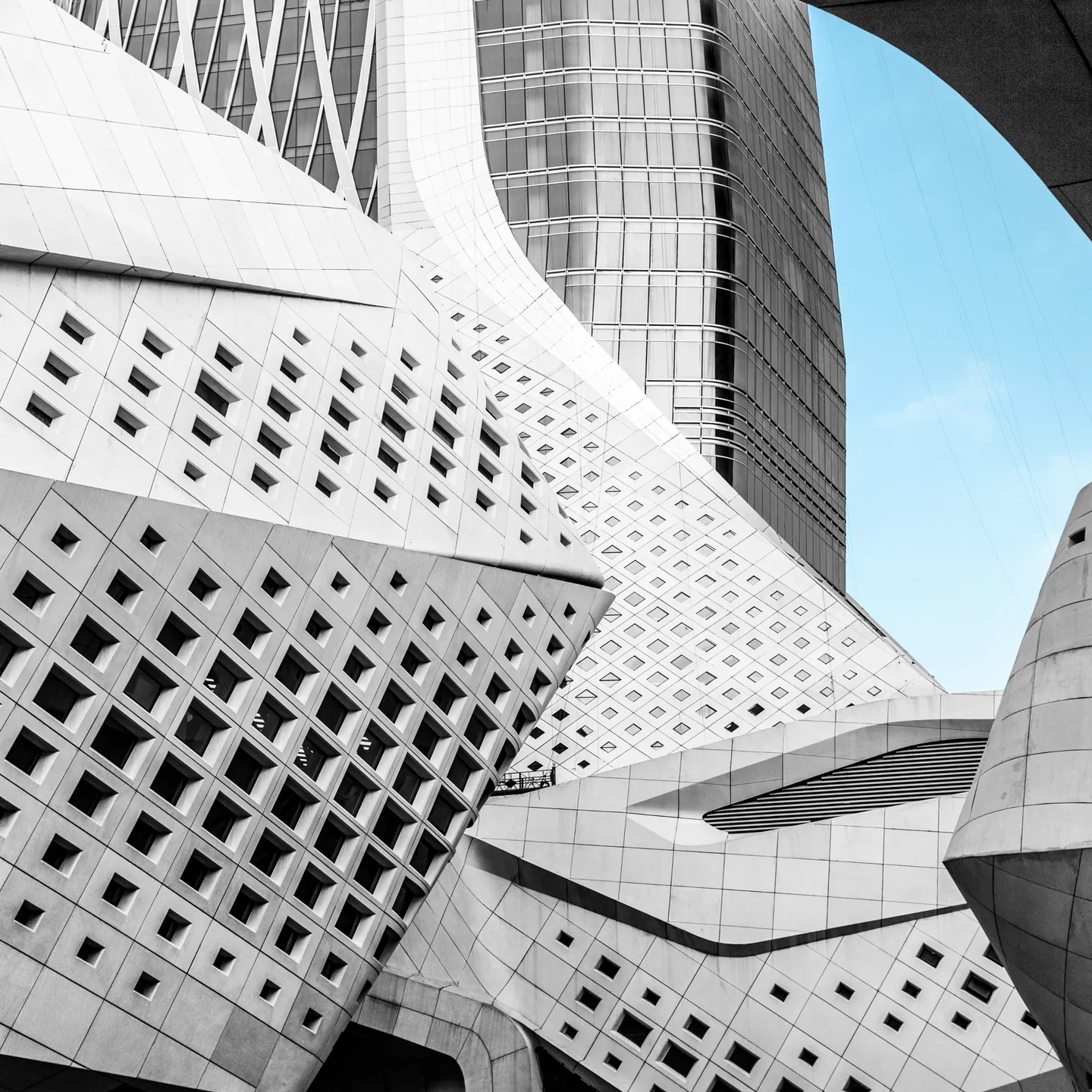 White parametric facade of a modern building against a blue sky